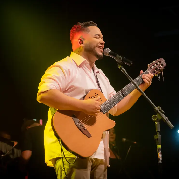 Foto de Matheus Vasconcelos com violão cantando